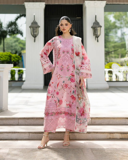 Woman wearing a pink floral outfit standing in front of a building with columns.