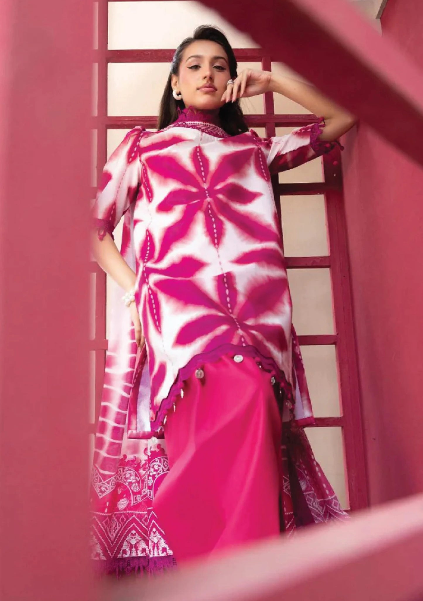 Low angle model portrait highlighting the vivid magenta pink geometric starburst layout on the shirt bodice code MB-ELHV4-04.