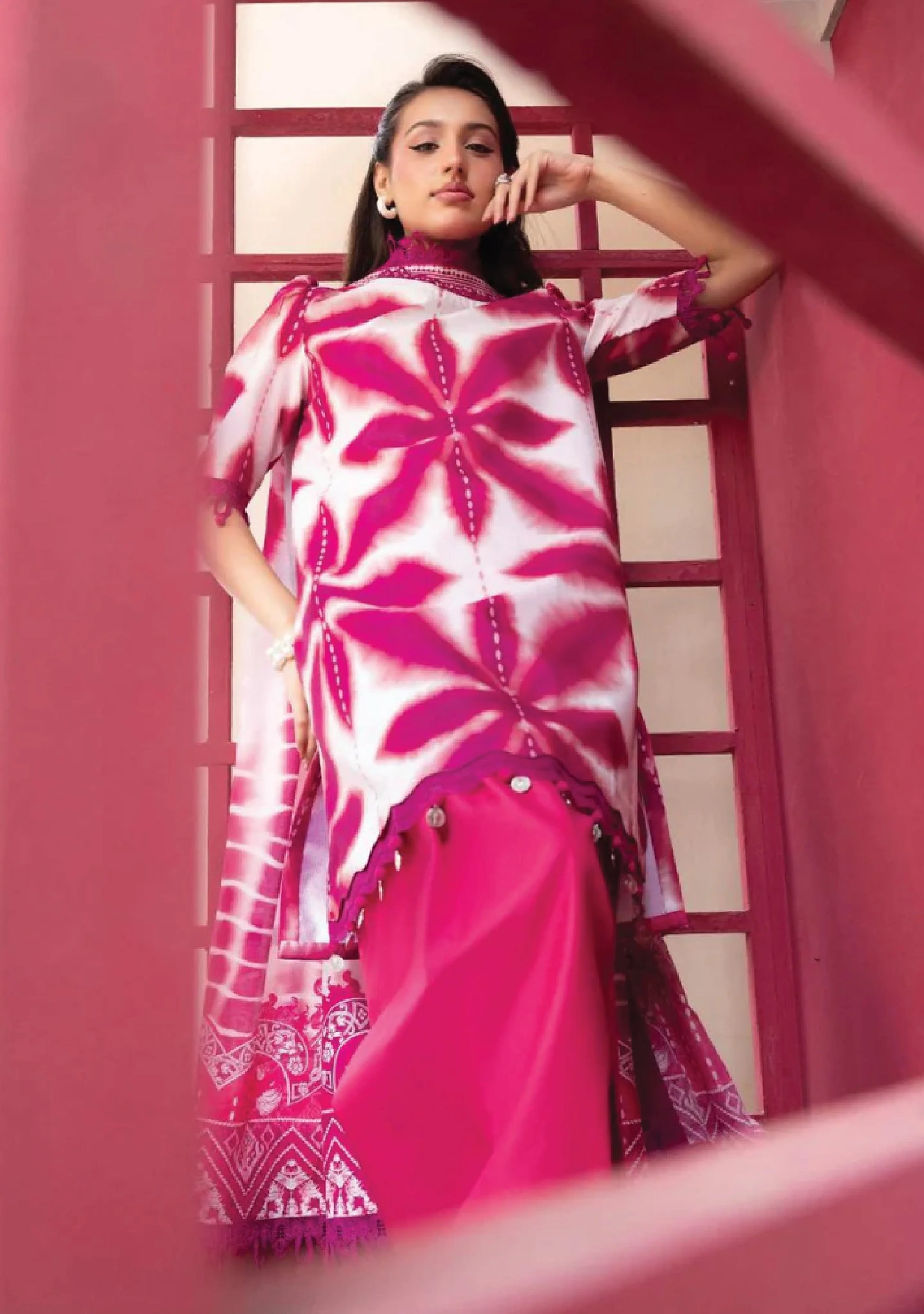 Low angle model portrait highlighting the vivid magenta pink geometric starburst layout on the shirt bodice code MB-ELHV4-04.