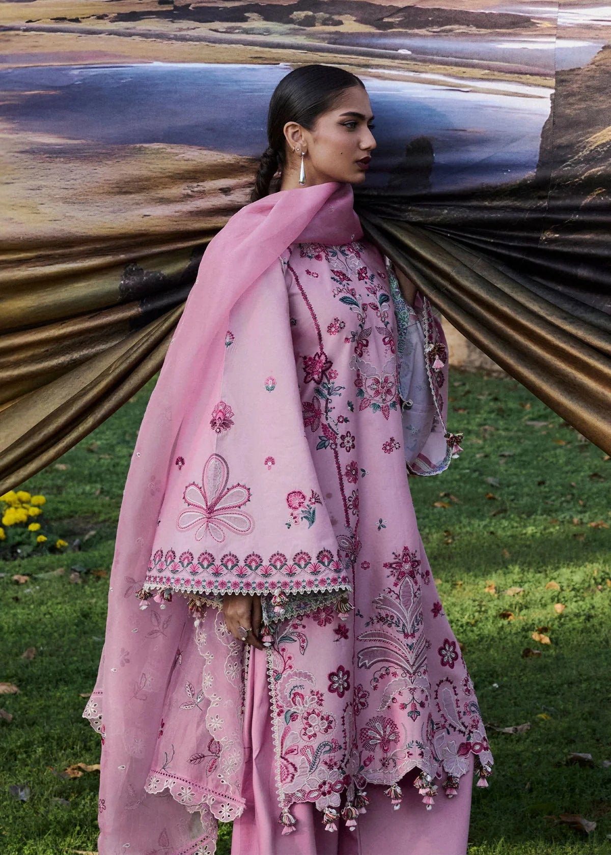Close-up front portrait focusing on the rich floral appliqué neckline embroidery details, green leaf accents, and sheer sleeve patches.