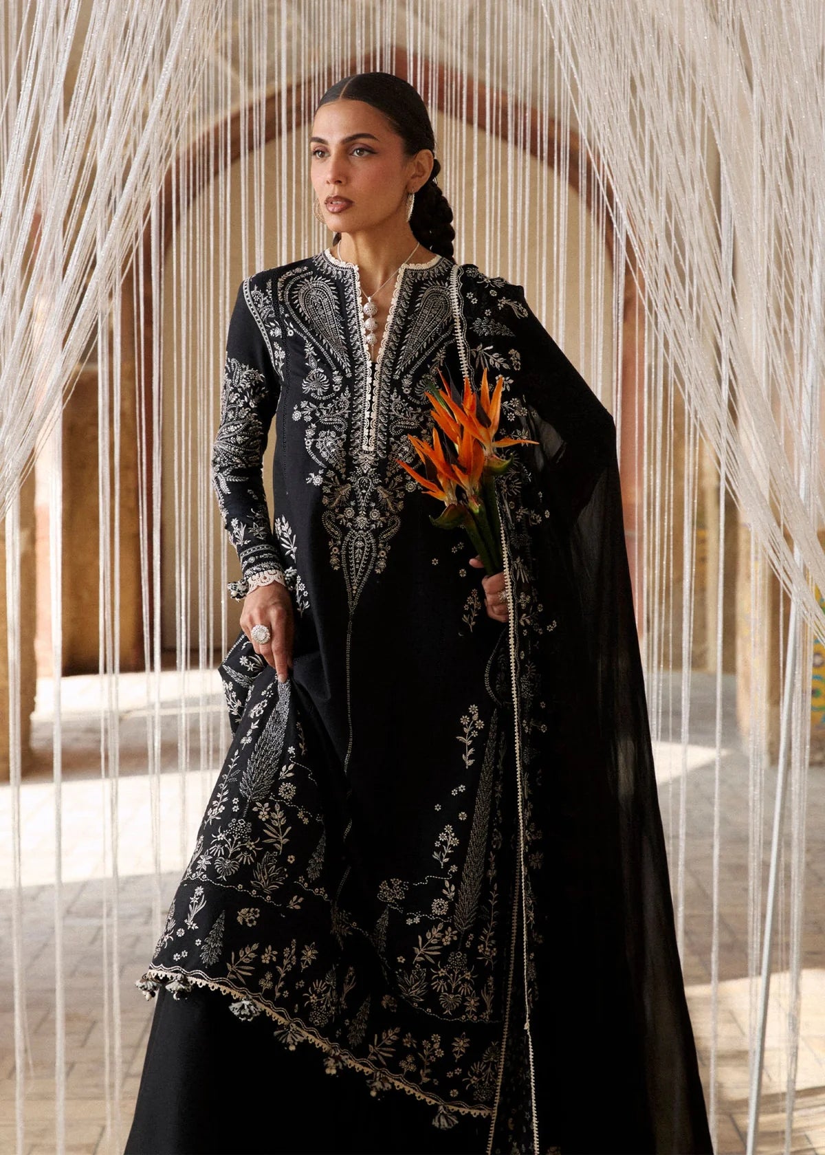 Full profile model layout presenting the long straight silhouette look, monochrome paneling structures, and solid trousers posture.