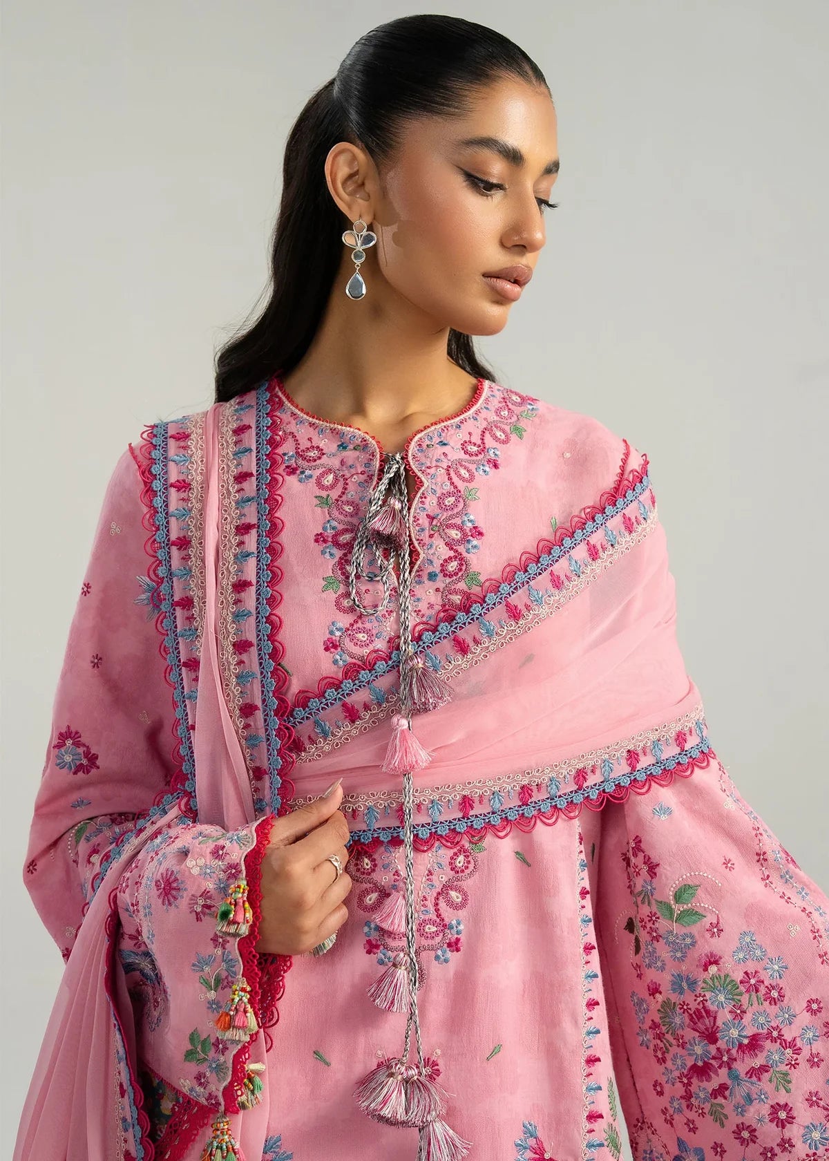 Close-up front view focusing on the detailed blue and magenta mirror style neckline embroidery and long pink tassel strings.