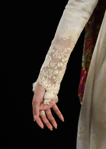 High-resolution focus on the sheer embroidered organza patch edge on the cuff finish of the long sleeves.